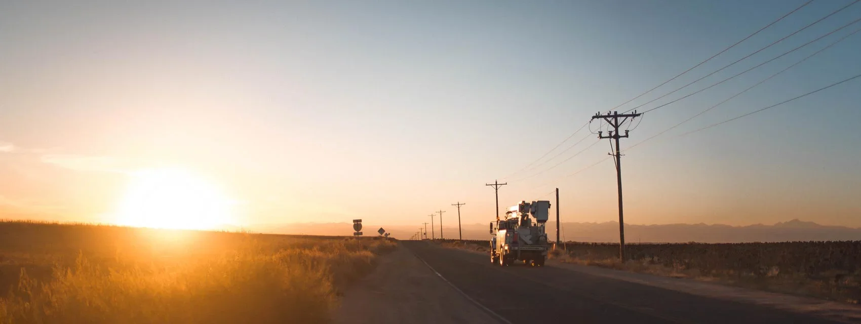 Coop Truck Driving Down Road Sundown